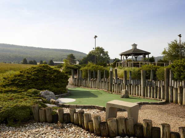 a fenced in lawn with a gazebo and a stone wall