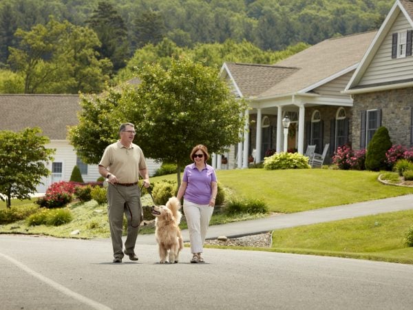 Couple walking dog in neighborhood