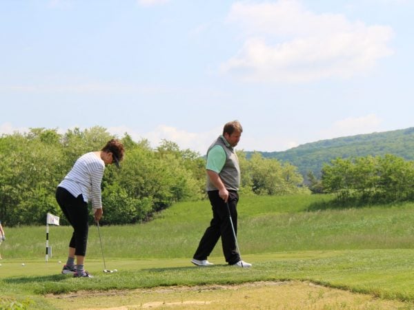 a man and woman playing golf