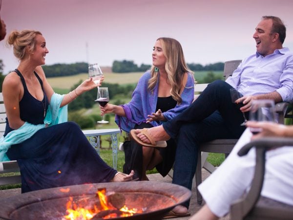 a group of people sitting around a fire with a fire in the background