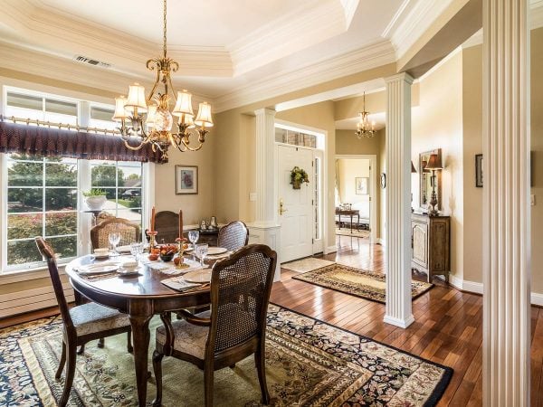 a dining room with a chandelier and a rug